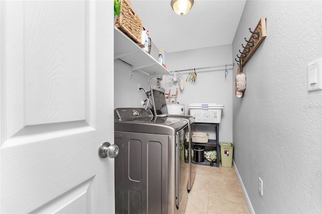 laundry area with separate washer and dryer and light tile patterned flooring