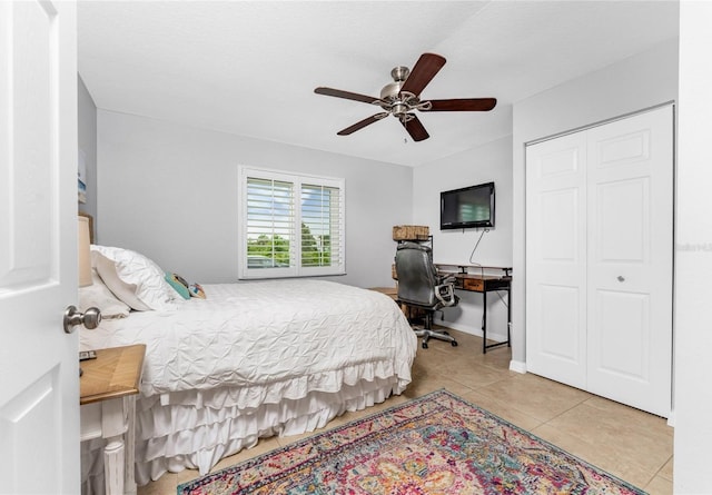 tiled bedroom featuring ceiling fan and a closet