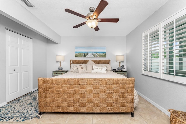 bedroom featuring a textured ceiling, tile patterned floors, and ceiling fan