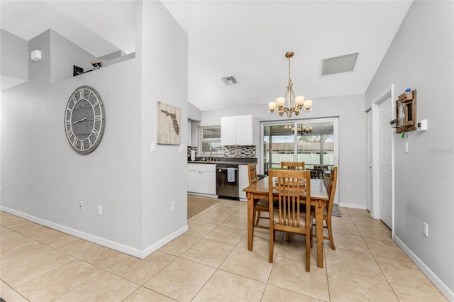 tiled dining room with lofted ceiling, sink, and a chandelier