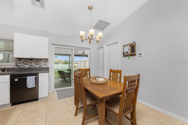 tiled dining area featuring plenty of natural light, lofted ceiling, and a chandelier