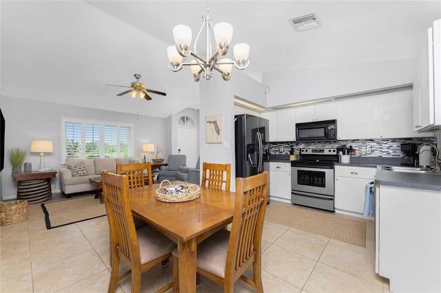 dining room with vaulted ceiling, ceiling fan with notable chandelier, sink, and light tile patterned floors