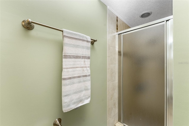 bathroom with a textured ceiling and walk in shower