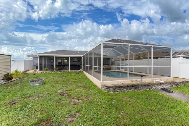 back of house with a fenced in pool, a lanai, and a lawn