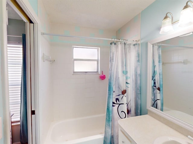 bathroom with vanity, shower / bathtub combination with curtain, and a textured ceiling