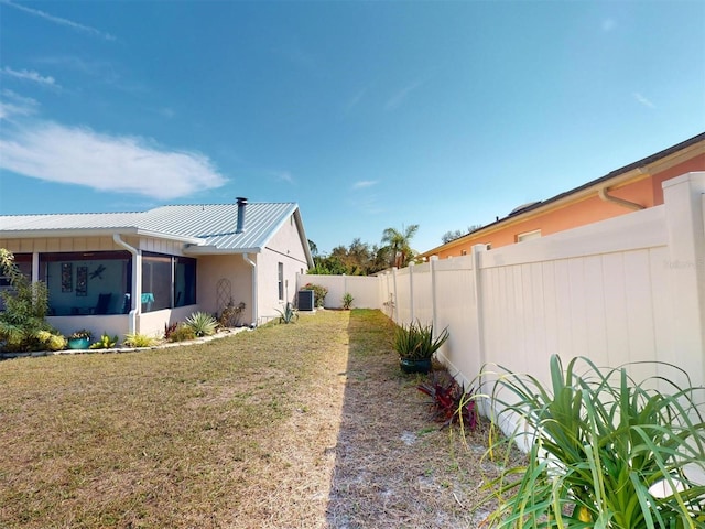 view of side of property with a yard and central AC unit