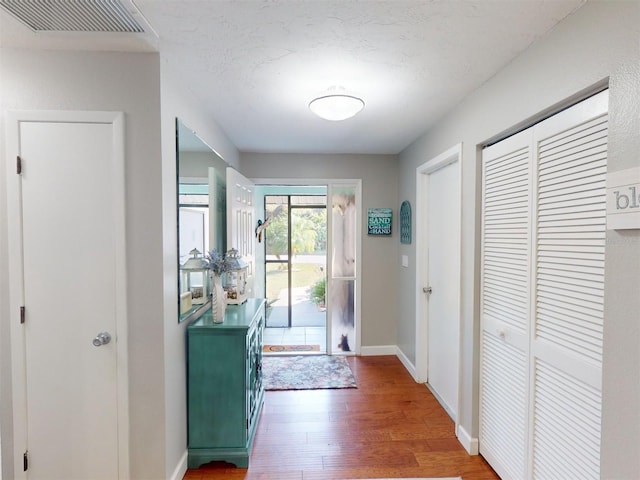 doorway to outside featuring dark hardwood / wood-style floors and a textured ceiling