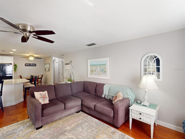 living room with hardwood / wood-style flooring and ceiling fan