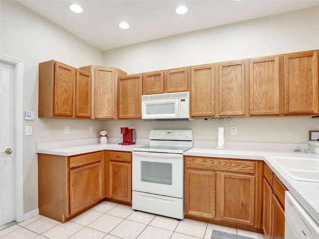 kitchen featuring sink, white appliances, and light tile patterned floors