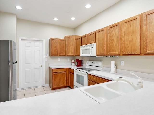 kitchen with white appliances, sink, and light tile patterned floors