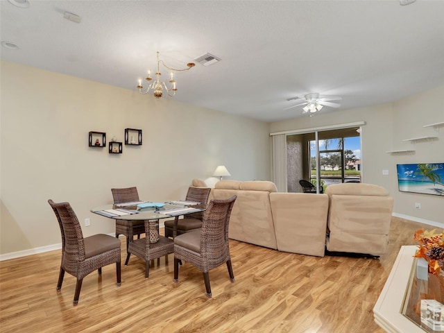 dining space featuring ceiling fan with notable chandelier and light hardwood / wood-style flooring