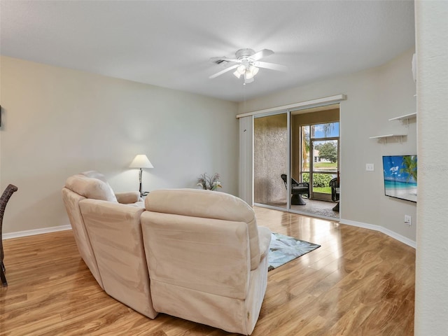 living room with light hardwood / wood-style flooring and ceiling fan