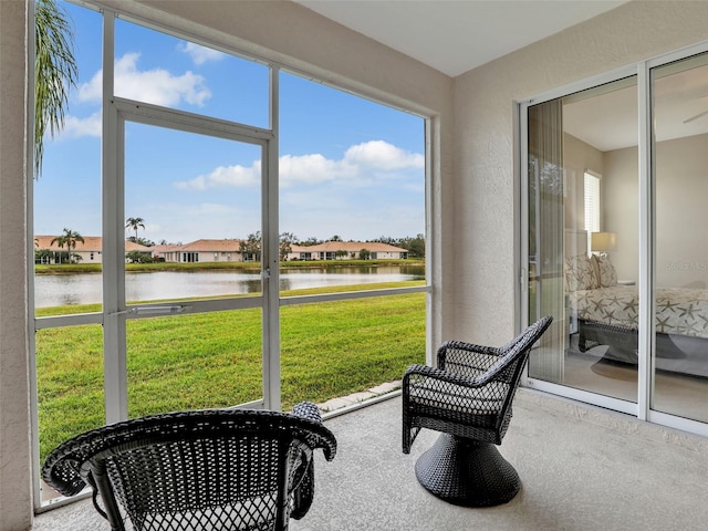 sunroom featuring a water view