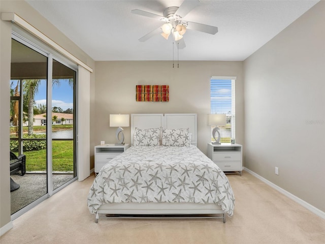 bedroom featuring ceiling fan, light colored carpet, access to exterior, and a water view