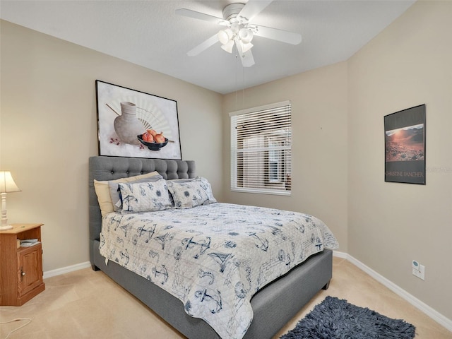 bedroom with ceiling fan and light carpet