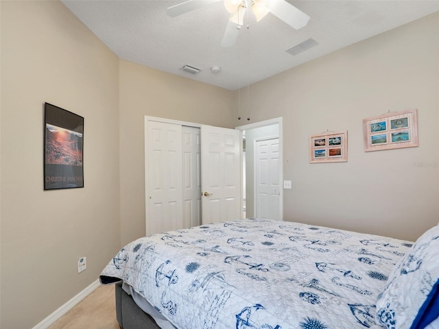 carpeted bedroom featuring ceiling fan, a closet, and a textured ceiling