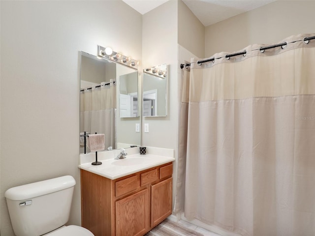 bathroom featuring vanity, a shower with shower curtain, and toilet