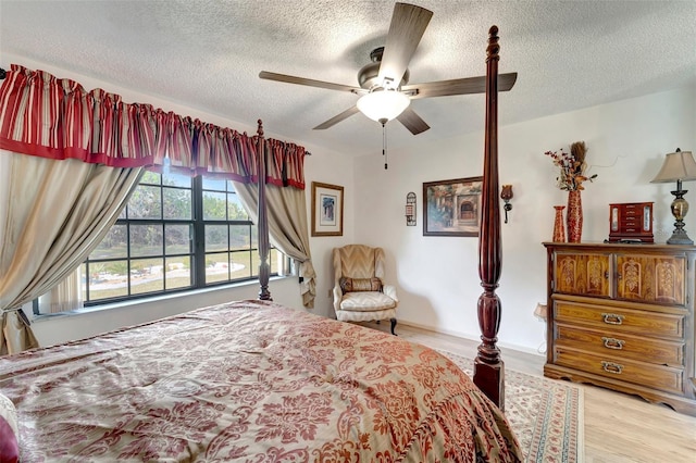 bedroom featuring ceiling fan, a textured ceiling, and light wood-type flooring