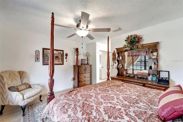 bedroom featuring hardwood / wood-style floors, a textured ceiling, and ceiling fan