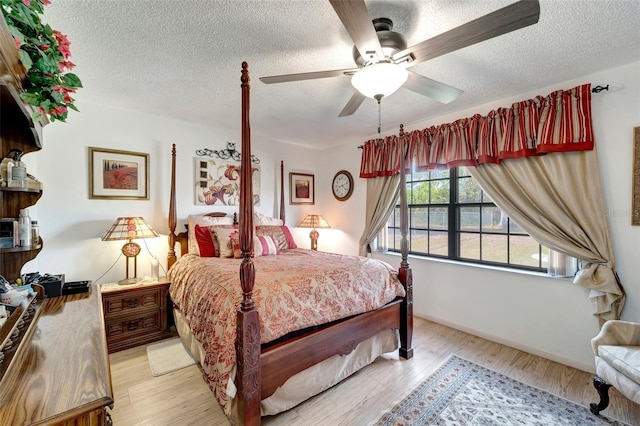 bedroom with ceiling fan, a textured ceiling, and light hardwood / wood-style floors