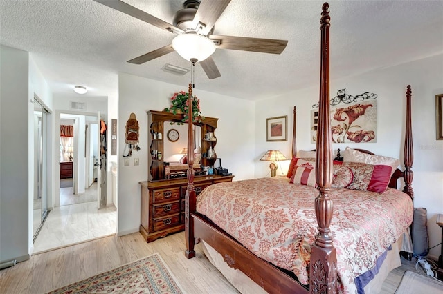 bedroom featuring ceiling fan, a textured ceiling, and light hardwood / wood-style flooring