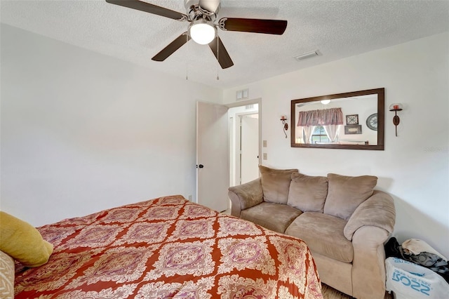 bedroom with ceiling fan and a textured ceiling