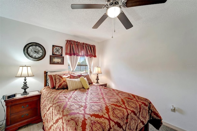 bedroom with ceiling fan, light carpet, and a textured ceiling