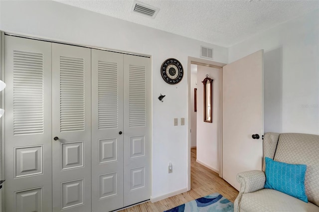 sitting room with a textured ceiling and light wood-type flooring