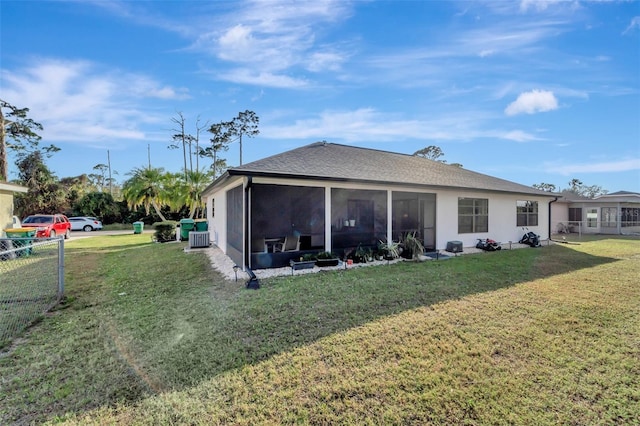 rear view of house featuring a yard and a sunroom