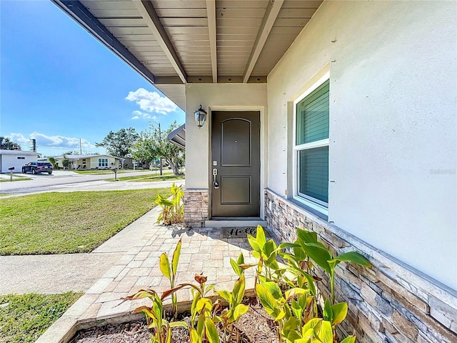 view of exterior entry with a lawn