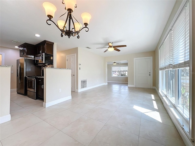 kitchen with hanging light fixtures, light tile patterned floors, light stone counters, stainless steel appliances, and dark brown cabinets