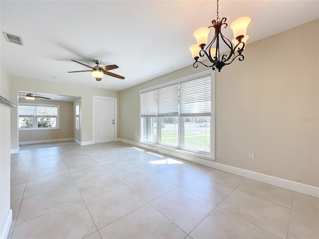 tiled spare room with ceiling fan with notable chandelier