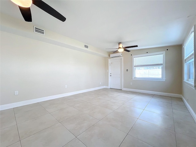 spare room with a wall mounted air conditioner, ceiling fan, and light tile patterned flooring