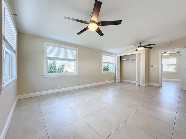 unfurnished bedroom with light tile patterned floors, a closet, and ceiling fan