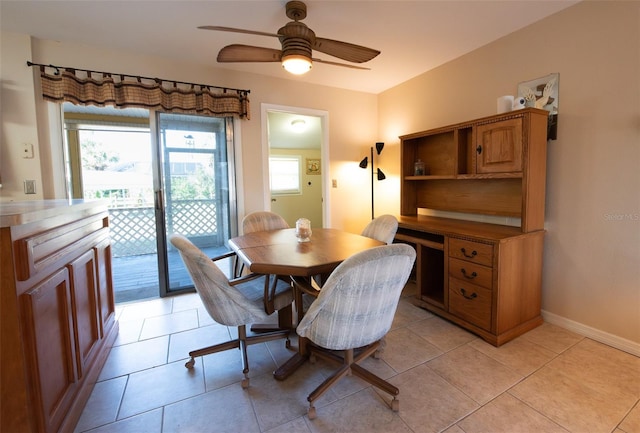 tiled dining space featuring plenty of natural light and ceiling fan