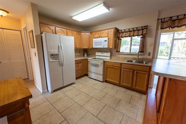 kitchen featuring sink, light tile patterned floors, and white appliances