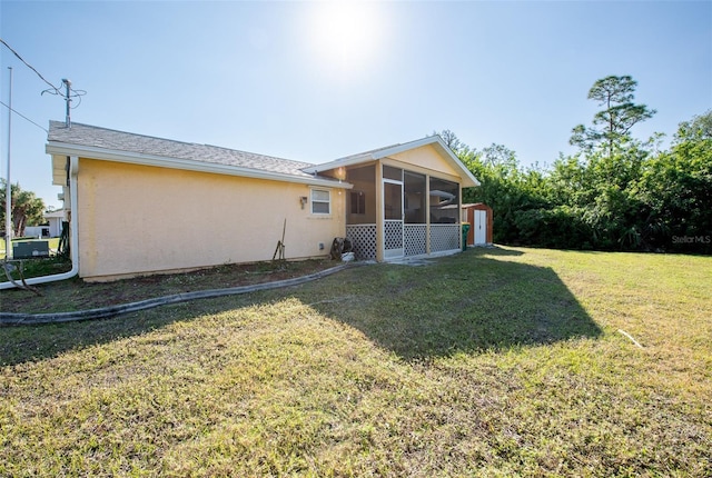 rear view of property featuring a yard and a sunroom