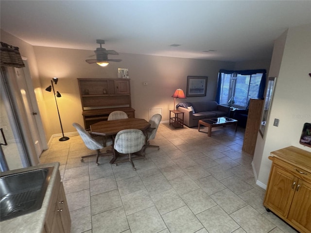 dining area featuring ceiling fan and baseboards