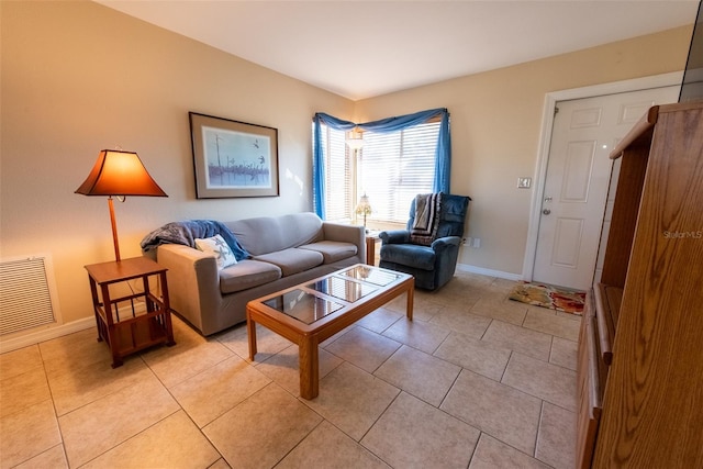 living room featuring light tile patterned flooring, visible vents, and baseboards