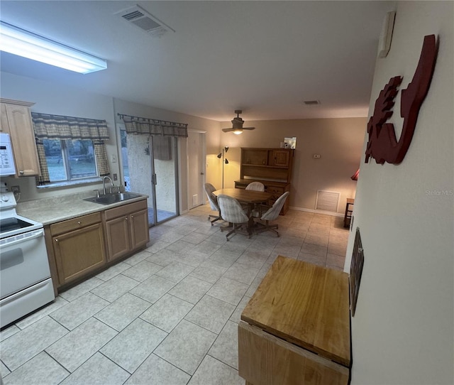 kitchen featuring white appliances, visible vents, ceiling fan, light countertops, and a sink