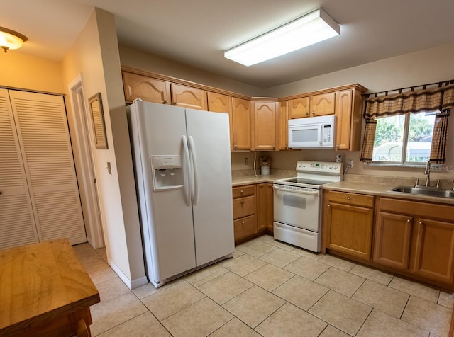 kitchen featuring light tile patterned floors, light countertops, white appliances, and a sink