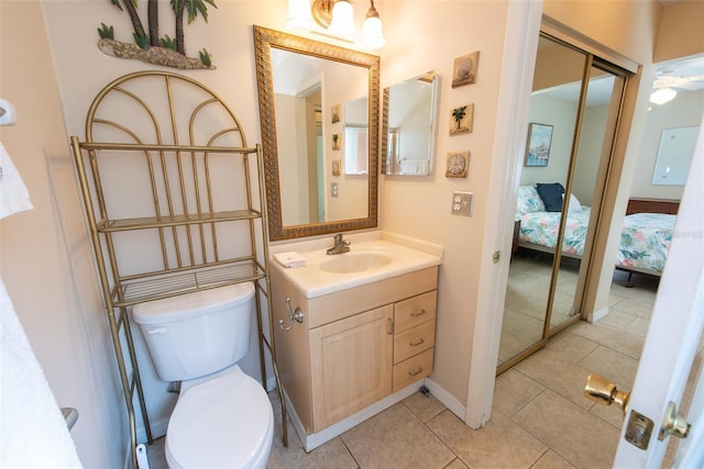 bathroom with ensuite bathroom, tile patterned flooring, toilet, vanity, and baseboards