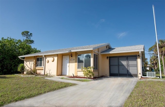 ranch-style house featuring a garage, central air condition unit, a front yard, and stucco siding