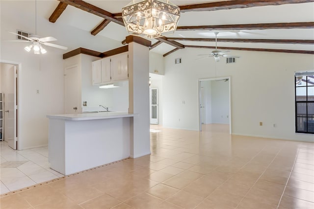 kitchen featuring ceiling fan with notable chandelier, decorative light fixtures, beamed ceiling, sink, and light tile patterned floors