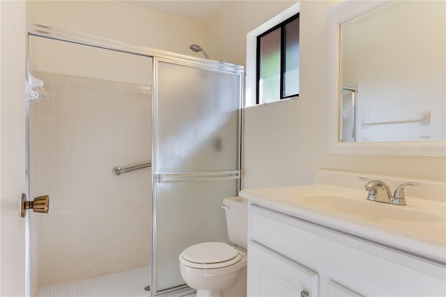 bathroom with walk in shower, vanity, and toilet