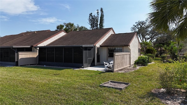 back of property featuring a lawn, a sunroom, and a patio