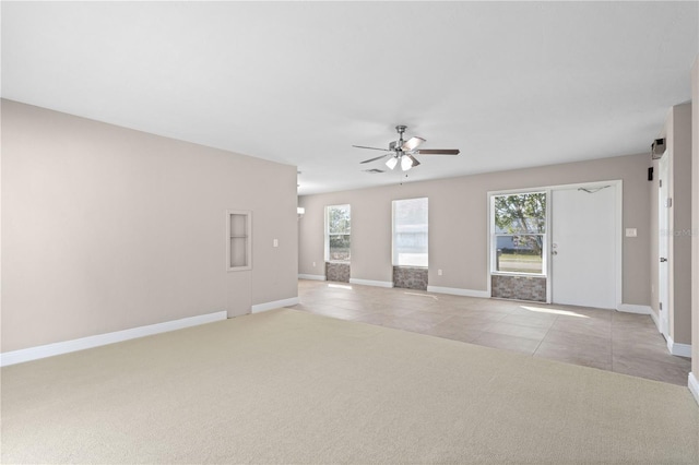 unfurnished living room featuring a healthy amount of sunlight, light colored carpet, and ceiling fan