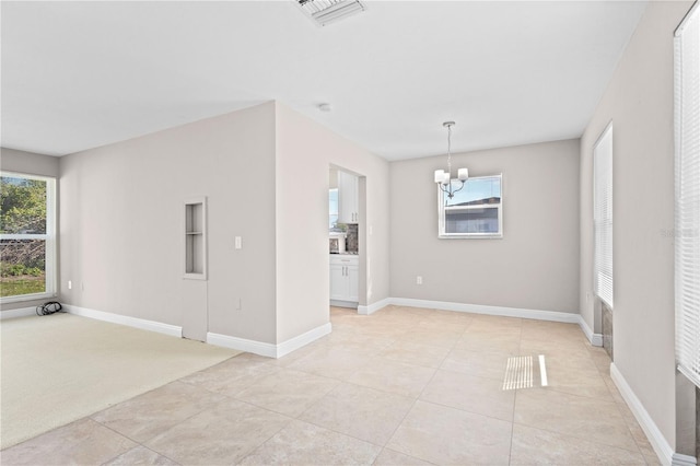 tiled empty room featuring a chandelier