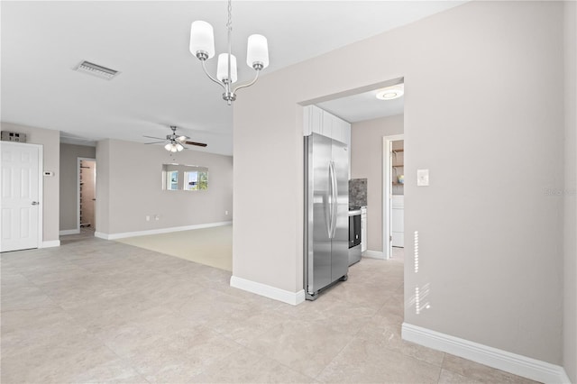 spare room with ceiling fan with notable chandelier