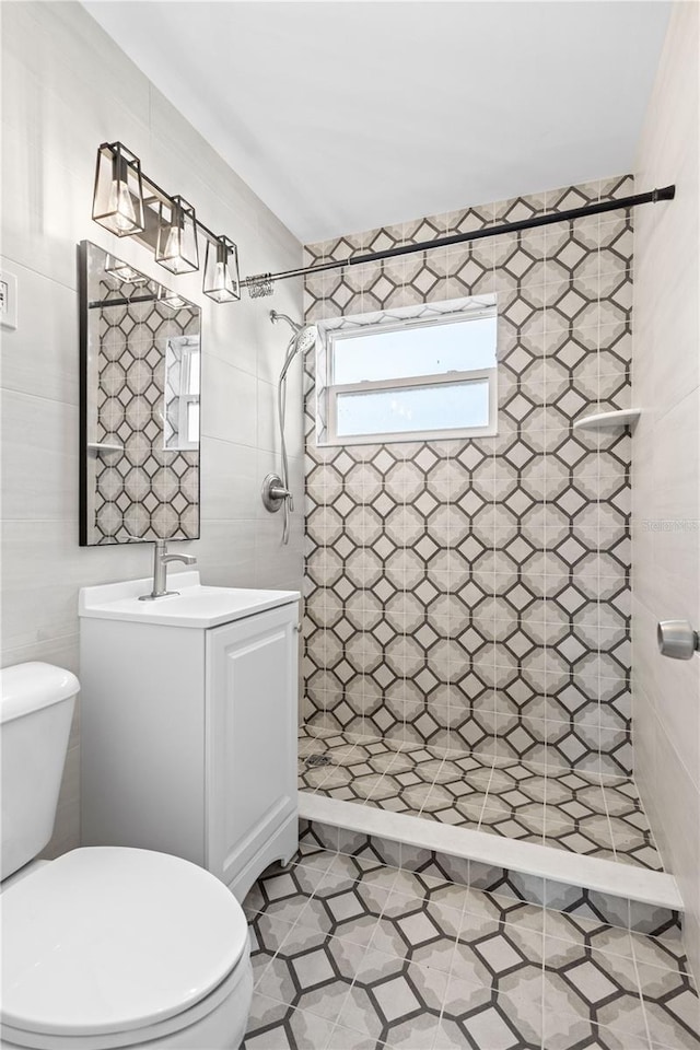 bathroom featuring vanity, toilet, and a tile shower